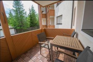 a balcony with a table and chairs and a window at Familienapartment Sonne und Schnee in Kanzelhöhe