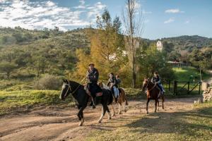 a group of people riding horses down a dirt road at Cabaña Molle by Lugar in El Manzano