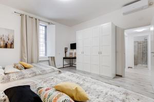 a white bedroom with white cabinets and a bed at Jmartins Colosseo Suites in Rome