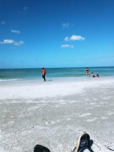 een persoon die op een strand staat met zijn voeten in het zand bij Tropical Paradise Oasis Spa Retreat in Largo