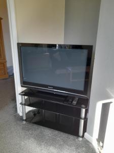 a flat screen tv sitting on a black stand at Home from Home in Faversham