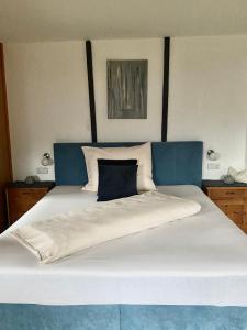 a large bed with a blue headboard and white sheets at Bauernhaus in Kolsassberg