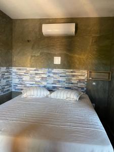 - une chambre avec un lit et un mur en briques dans l'établissement Pousada Nascer da Lua, à Fortim