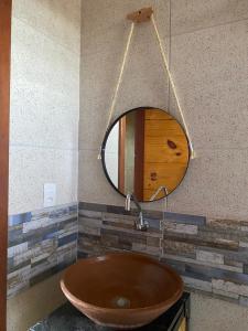 a bathroom with a wooden sink and a mirror at Pousada Nascer da Lua in Fortim