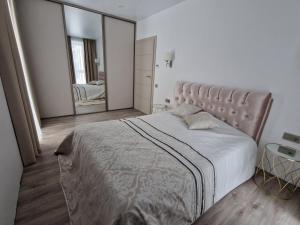 a bedroom with a large bed and a large mirror at Life Story in Kaunas