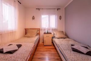 2 camas en una habitación con 2 ventanas en Domek bez zegara en Lądek-Zdrój
