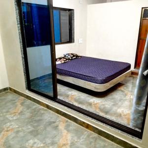een bed in een kamer met een spiegel bij Shobhnath Home Stay in Harnai