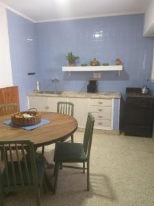 cocina con mesa y pared azul en ALQUILER DE CASA POR TEMPORADA en Necochea