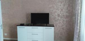 een tv op een witte dressoir in een kamer bij Apartament lux in Roman