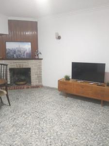 sala de estar con TV y chimenea en ALQUILER DE CASA POR TEMPORADA en Necochea