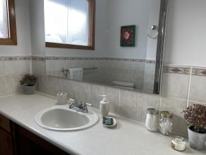 y baño con lavabo y espejo. en The North Escape Cozy 3 bedroom house Great location, en Sault Ste. Marie