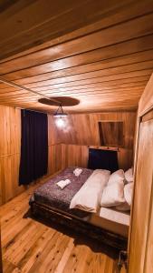 a bedroom with a bed in a wooden room at Feel Funny House in Kʼveda Marghi