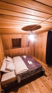 a bed in a wooden room with a ceiling at Feel Funny House in Kʼveda Marghi