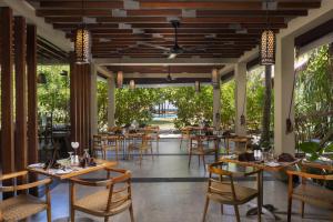 a restaurant with wooden tables and chairs and trees at Ayana Sea in Wadduwa