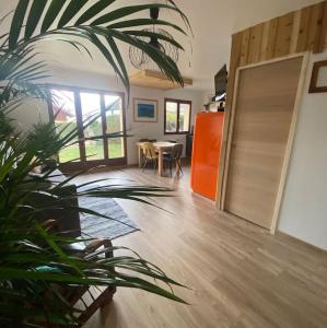 Sala de estar con puerta, mesa y planta en Appartement au calme avec vue sur les montagnes., en Sévrier