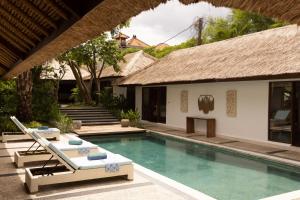 a villa with a swimming pool and a resort at Villa Lima Hati in Kerobokan