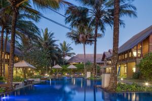 a resort pool with palm trees and umbrellas at Ayana Sea in Wadduwa
