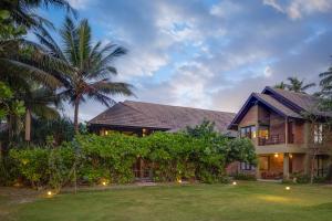 a house with palm trees in front of it at Ayana Sea in Wadduwa
