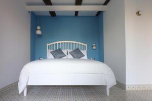 a bedroom with a white bed with blue walls at La Casa del Bosco - Unique two storey House with garden in Naples