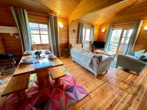ein Wohnzimmer mit einem Tisch und einem Sofa in der Unterkunft Lake Pochard, Oak Lodge in South Cerney
