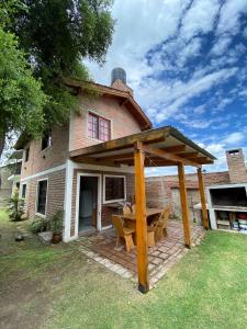 un pabellón con una mesa de picnic frente a una casa en Cabaña en el Centro de Mina Clavero en Mina Clavero