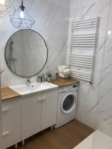 a bathroom with a washing machine and a mirror at Yellow Stone Apartment in Szczecin