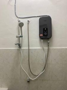 ein Handy, das an eine Dusche im Bad angeschlossen ist in der Unterkunft Homestay Bandar Temerloh Wi-Fi Netflix Smart TV in Temerloh