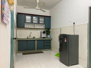 eine Küche mit blauen Schränken und einem Kühlschrank in der Unterkunft Homestay Bandar Temerloh Wi-Fi Netflix Smart TV in Temerloh