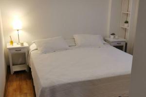um quarto com uma cama branca com duas mesas de cabeceira em Teodoro's Home em Buenos Aires