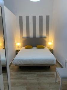 a bedroom with a bed with two yellow pillows at Casas La Aldea Suites Plaza in San Nicolás