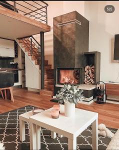 a living room with a fireplace and a table at The View - ski to door in Bjelašnica