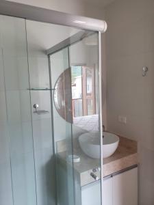 ein Badezimmer mit einer Glasdusche mit Waschbecken in der Unterkunft Casas a 5 min do Centro Histórico in Paraty