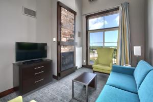 a living room with a blue couch and a television at Blue Mountain Resort Mosaic Suites in Blue Mountains