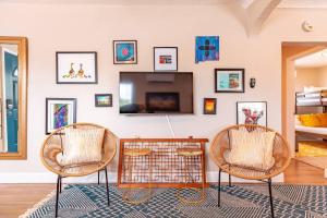 a living room with two chairs and a tv at The Patito: Walk to the Zoo, Cafes and Restaurants in Albuquerque