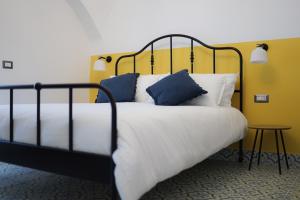 Schlafzimmer mit einem Bett mit blauen und weißen Kissen in der Unterkunft La Casa del Bosco - Unique two storey House with garden in Neapel