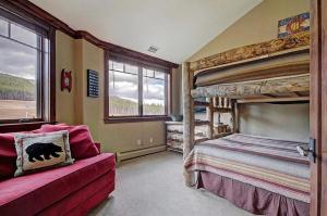 Crystal Peak Penthouse في بريكنريدج: غرفة نوم مع سريرين بطابقين وأريكة