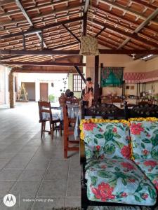 Zimmer mit einem Tisch, Stühlen und Kissen in der Unterkunft Pousada Sol de Verão in São Pedro da Aldeia