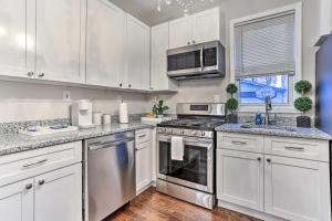 a kitchen with white cabinets and stainless steel appliances at Newark Townhome Near Airport - Pet Friendly! in Newark