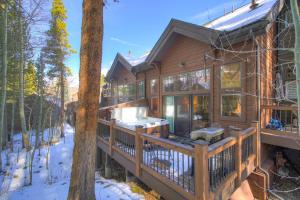 a log home with a covered deck in the snow at Village Point in Breckenridge