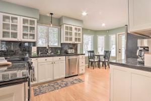 a kitchen with white cabinets and a dining room at Crystal Bay Home with Fireplace Near Ski Resorts in Post Falls