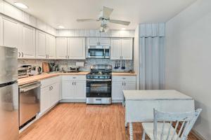 uma cozinha com armários brancos e um forno com placa de fogão em Cozy Cape May Escape Near Beaches and Golfing! em Cape May
