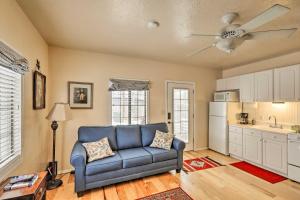 a living room with a blue couch and a kitchen at Williams Vacation Rental with Mountain View! in Williams