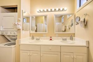 a bathroom with two sinks and a washer and dryer at Williams Vacation Rental with Mountain View! in Williams