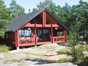 Cabaña roja con techo negro en Hinders Cottages en Nauvo