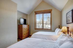 a bedroom with two beds and a tv and a window at Mountain Thunder #604 in Breckenridge +30 photos