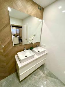 een badkamer met 2 wastafels en een grote spiegel bij Apartamento Cádiz Costa in Cádiz