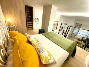 een slaapkamer met een bed met gele kussens bij Apartamento Cádiz Costa in Cádiz