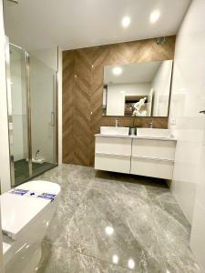 een badkamer met een toilet, een wastafel en een spiegel bij Apartamento Cádiz Costa in Cádiz