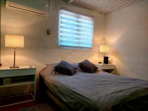 a bedroom with a bed with two pillows and a window at Apartment Villa Valentina - Studio 2 in Noord