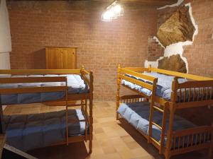 Zimmer mit 3 Etagenbetten und Ziegelwand in der Unterkunft Apartamento Valdelinares,Casa la roca in Valdelinares